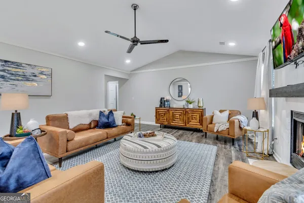 a living room with furniture a fireplace and a flat screen tv