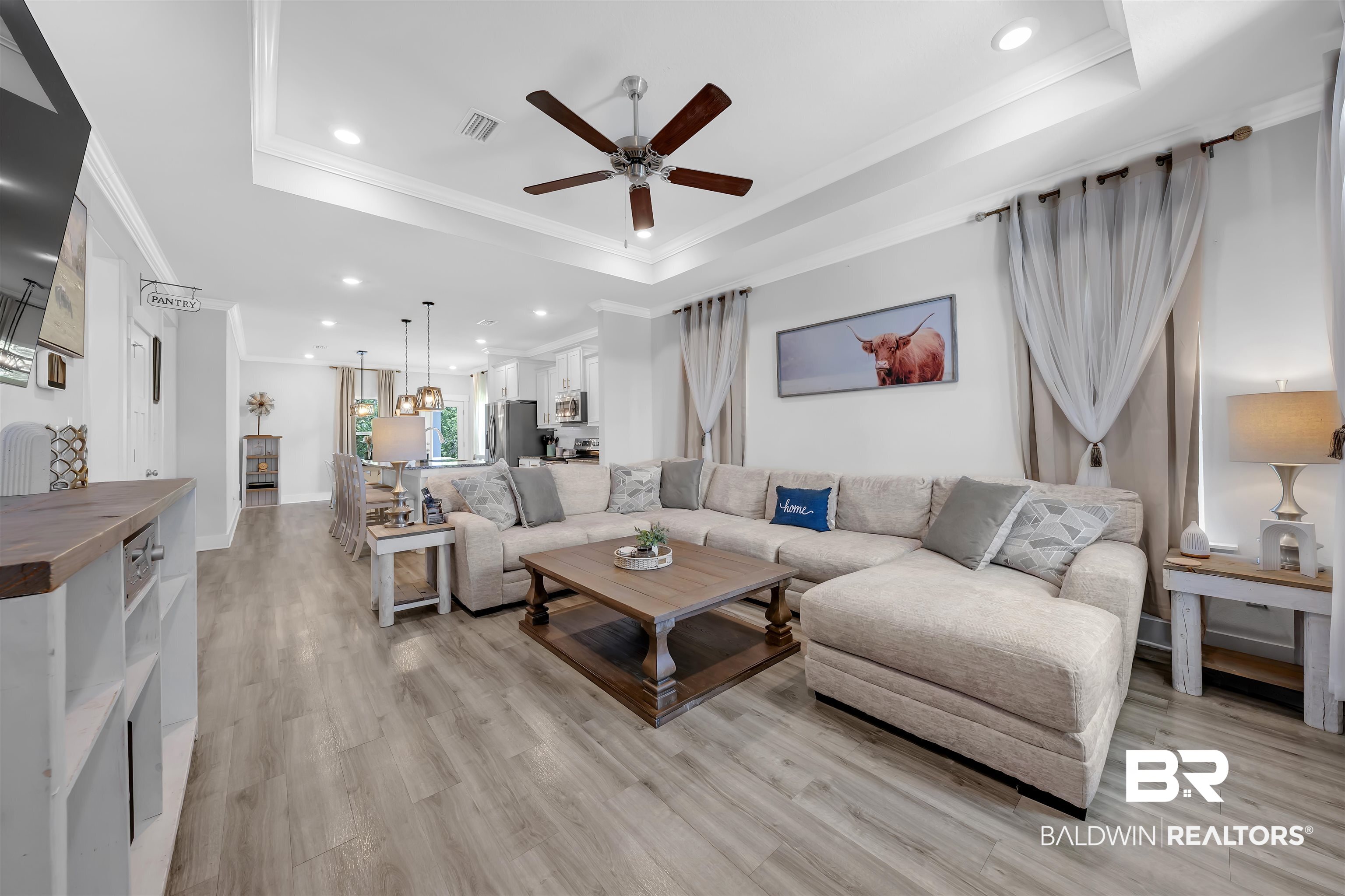 16504 Prado Loop Loxley, AL 36551 - Photo 6 of 45 Living room with a tray ceiling, a ceiling fan, recessed lighting, light wood finished floors, and crown molding