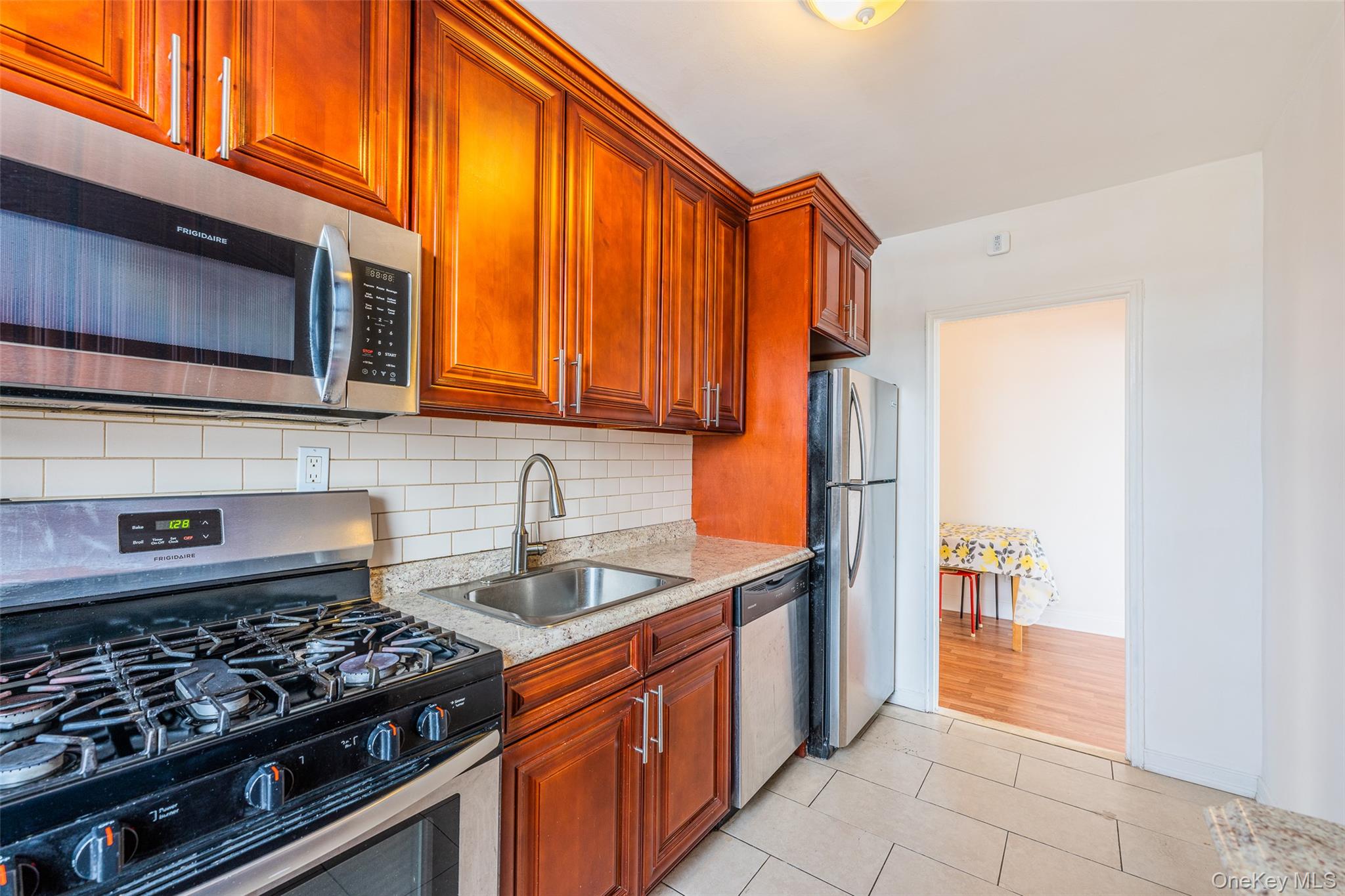 150-15 72nd Road, Unit 5G Queens, NY 11367 - Photo 6 of 27 a kitchen with stainless steel appliances granite countertop a stove and a microwave