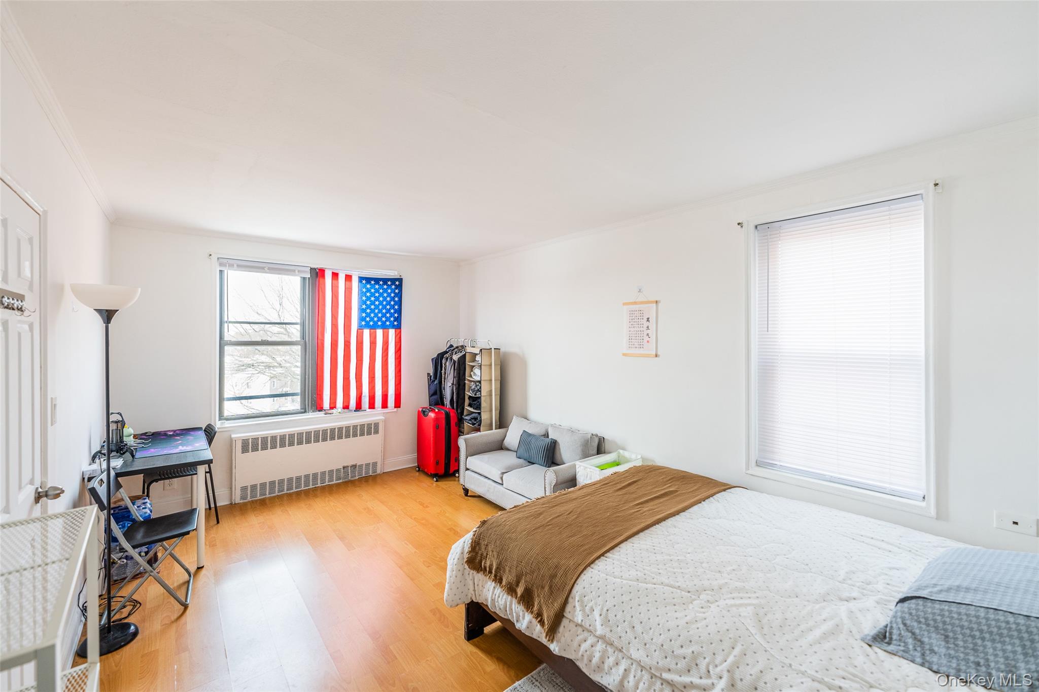 150-15 72nd Road, Unit 5G Queens, NY 11367 - Photo 10 of 27 a bedroom with a bed and wooden floor