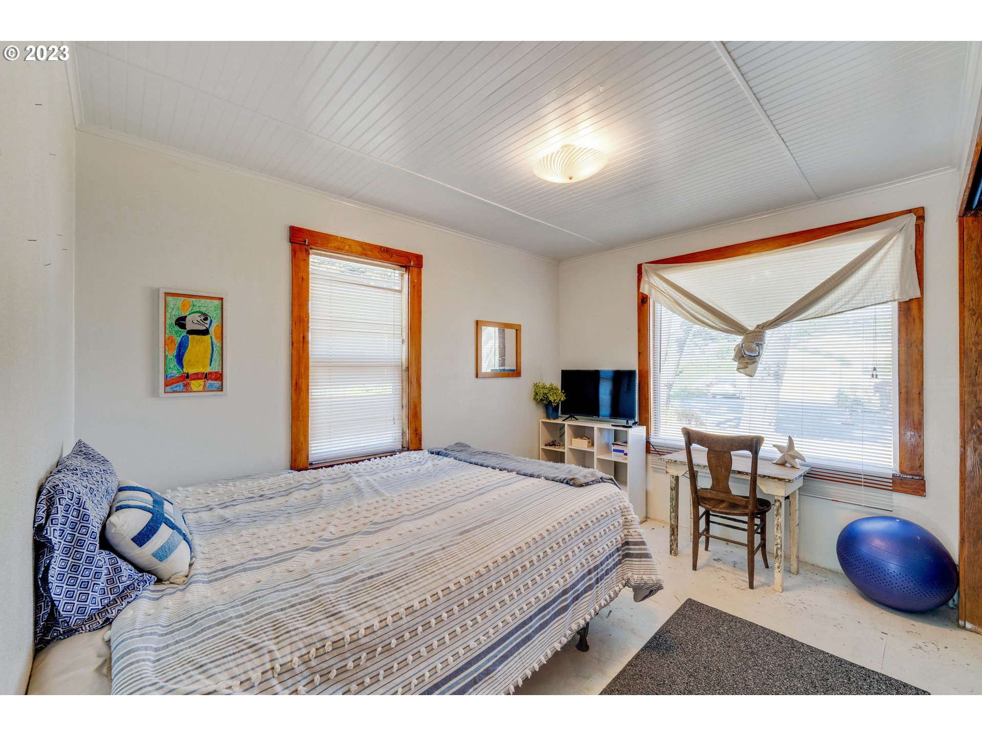 535 Edison Avenue Southwest Bandon, OR 97411 - Photo 20 of 33 a bedroom with a bed a table and painting next to a window