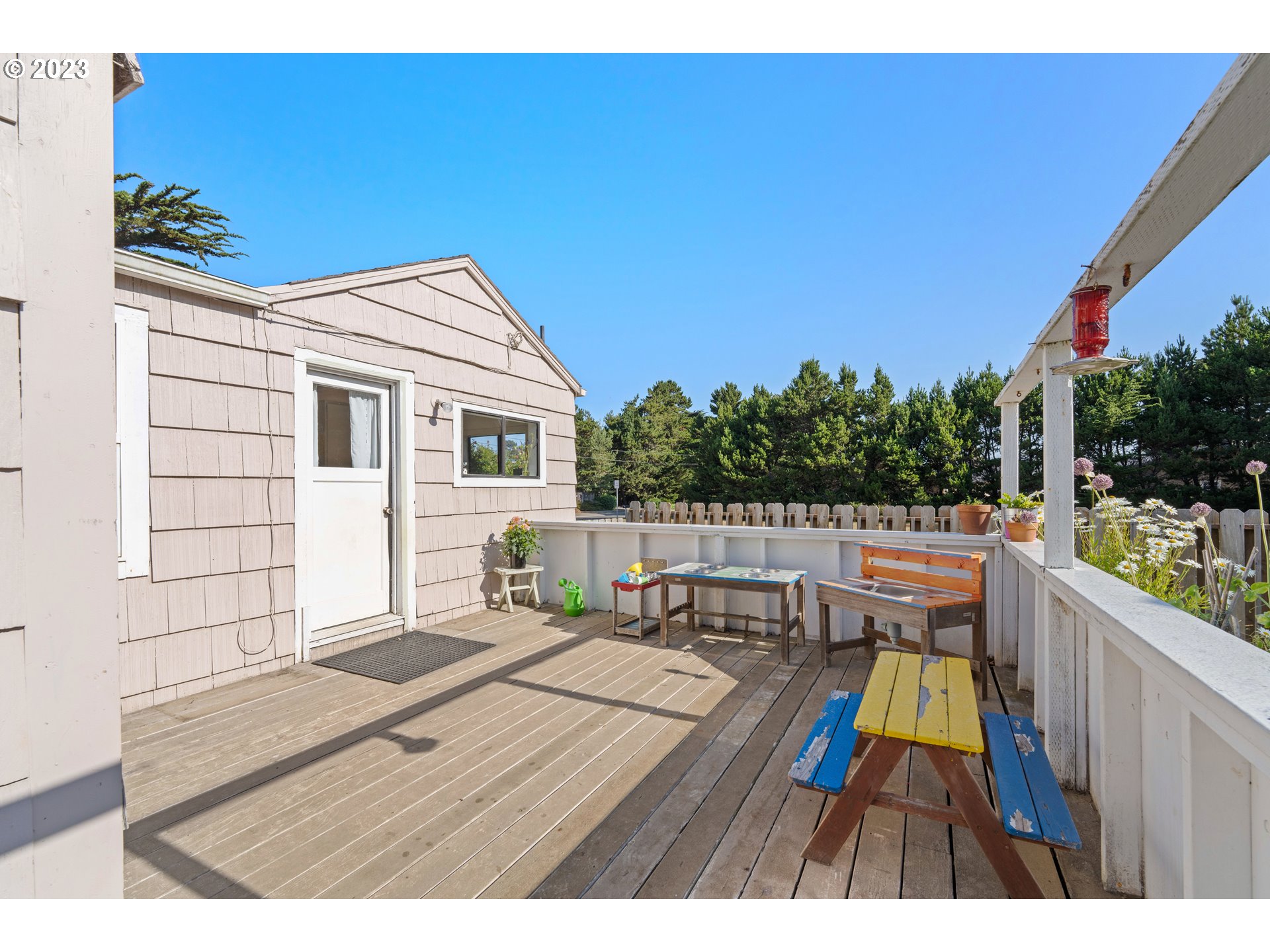 535 Edison Avenue Southwest Bandon, OR 97411 - Photo 24 of 33 a balcony with wooden floor table and chairs
