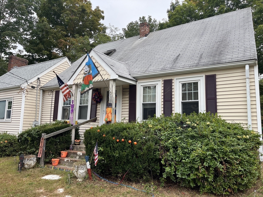 240 Spring Street Hanson, MA 02341 - Photo 3 of 20 a view of a white house with large windows and a table and chairs