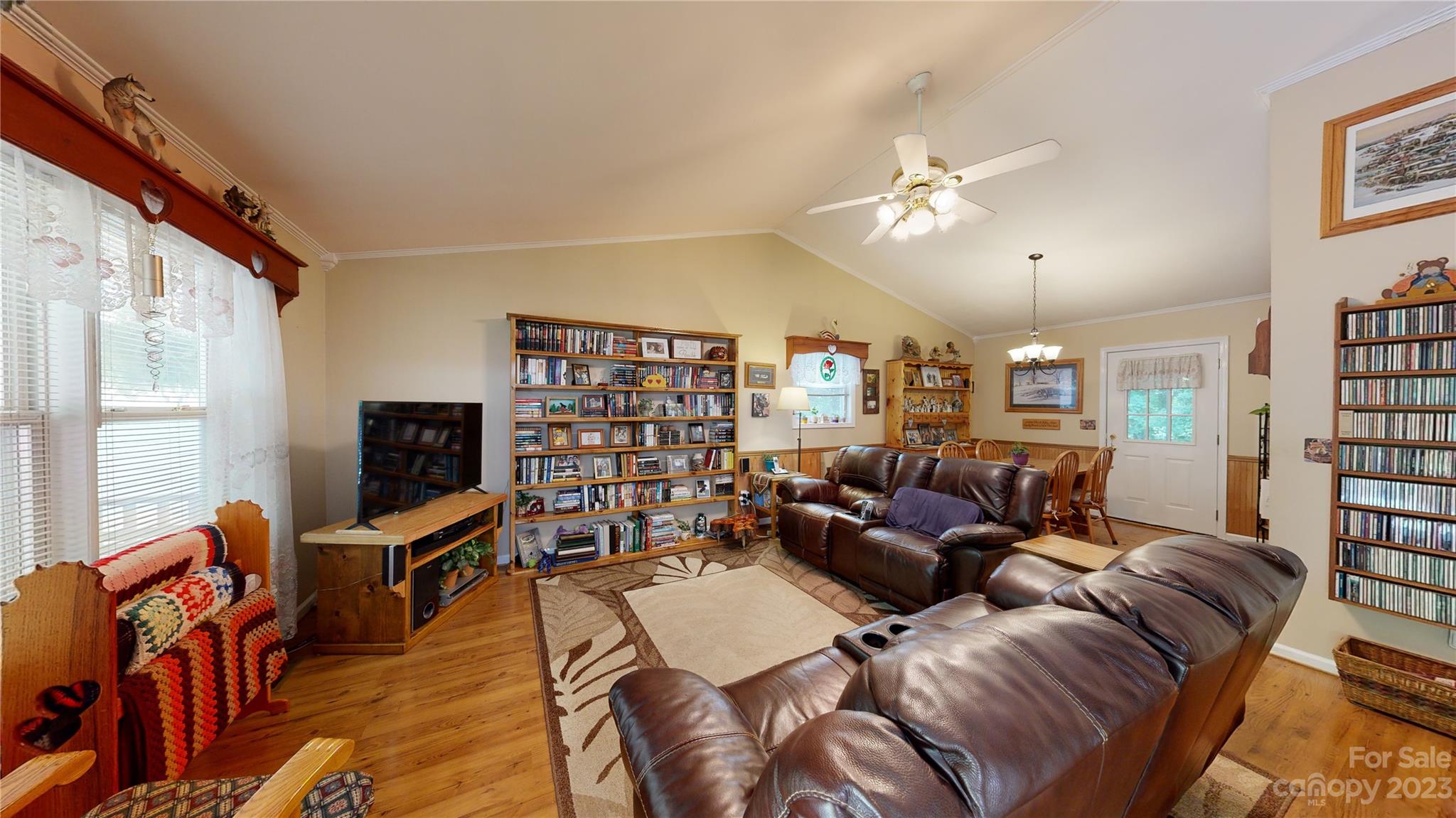 4211 Staton Road Hendersonville, NC 28739 - Photo 38 of 43 a living room with furniture a bookshelf and a flat screen tv