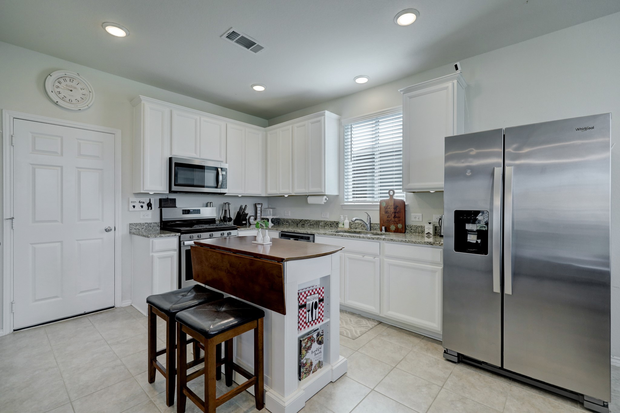 25735 Royal Catchfly Road Katy, TX 77493 - Photo 3 of 31 The kitchen features tile floors, abundance of white cabinetry, granite countertops, and stainless steel appliances.