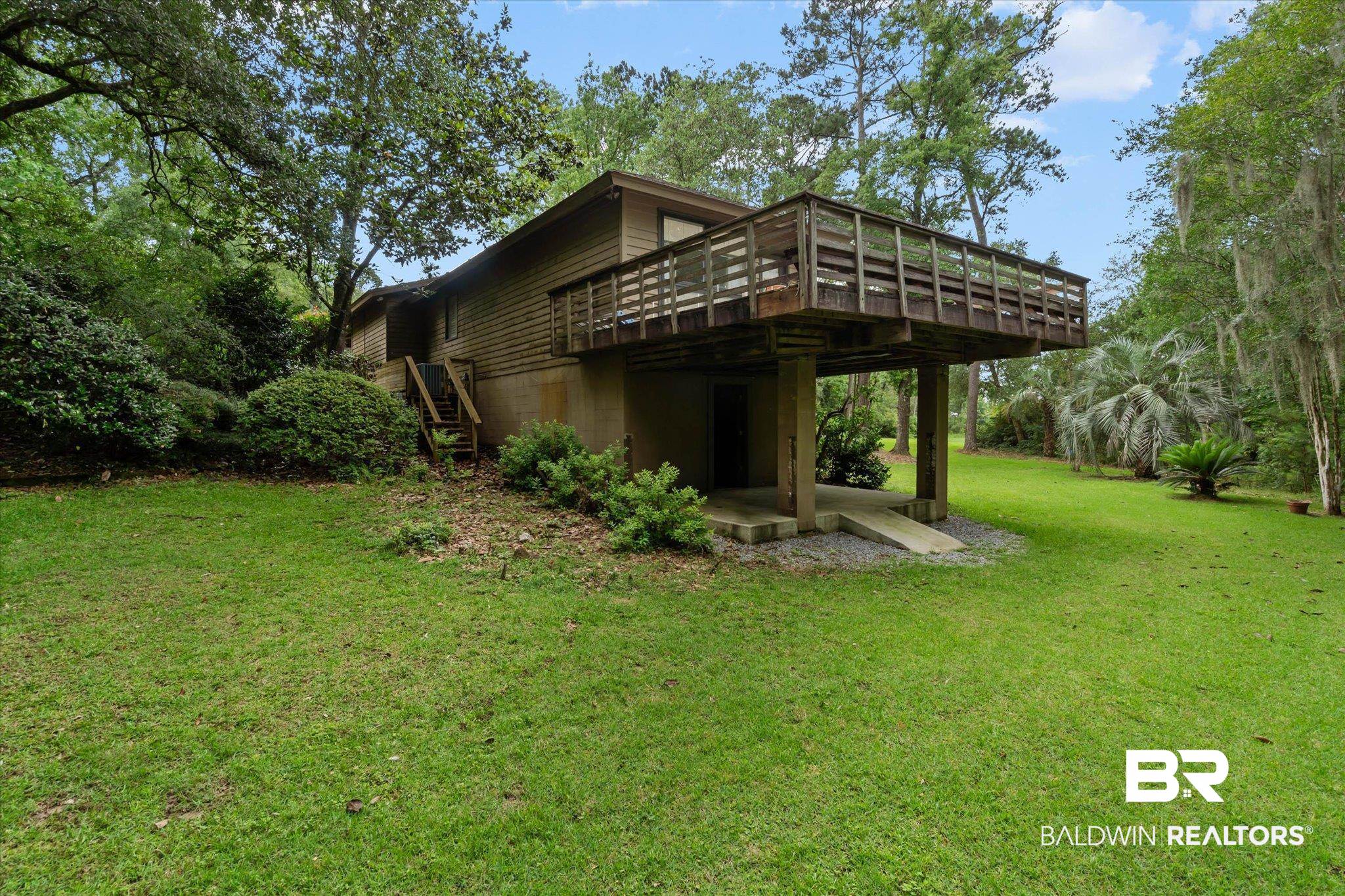3500 Venetia Road Mobile, AL 36605 - Photo 37 of 56 Spacious backyard featuring a large wooden deck, expansive lawn, mature trees, and established shrubbery