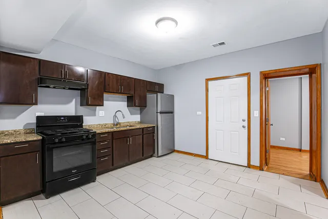 a kitchen with stainless steel appliances granite countertop a stove and a refrigerator