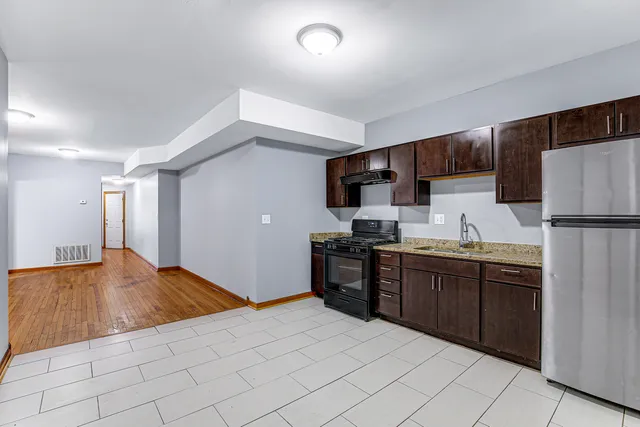 a kitchen with stainless steel appliances granite countertop a refrigerator and a sink