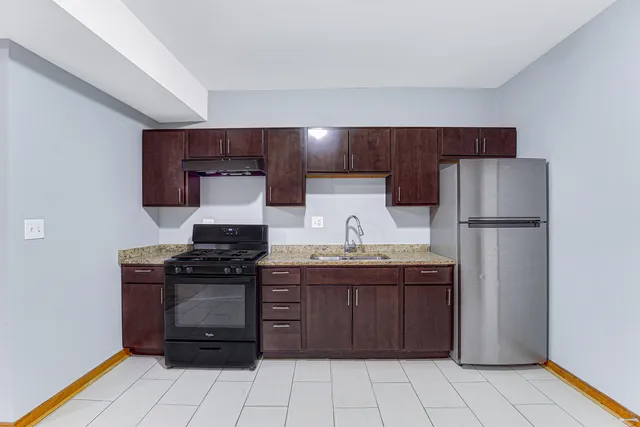 a kitchen with stainless steel appliances granite countertop a stove a refrigerator and a sink