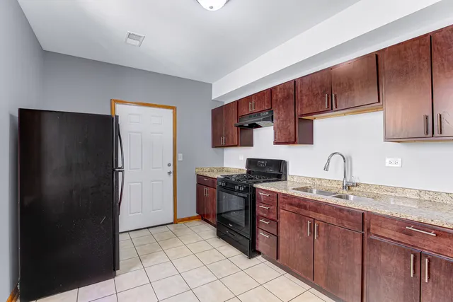 a kitchen with stainless steel appliances granite countertop a refrigerator and a sink