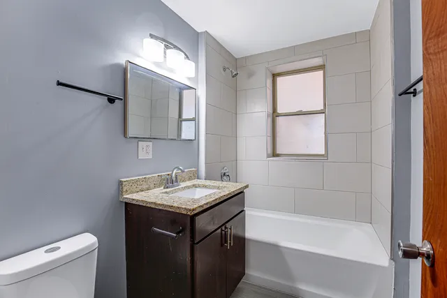 a bathroom with a sink toilet vanity and shower