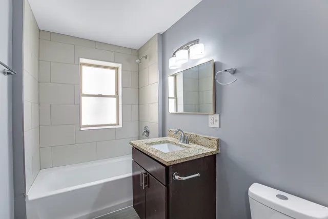 a bathroom with a bathtub sink vanity and toilet