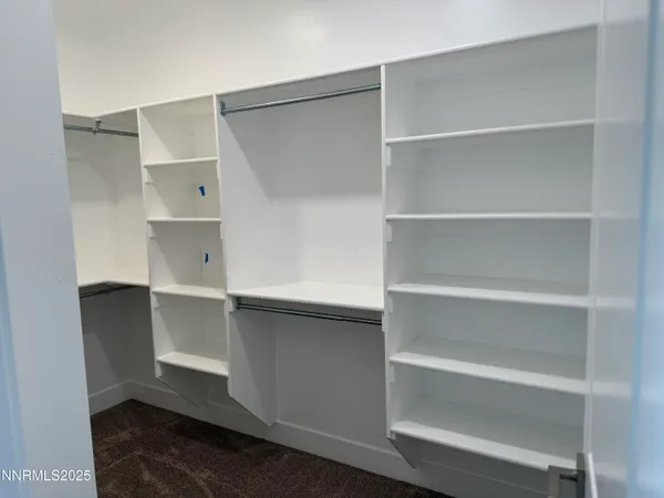 a view of walk in closet with empty racks