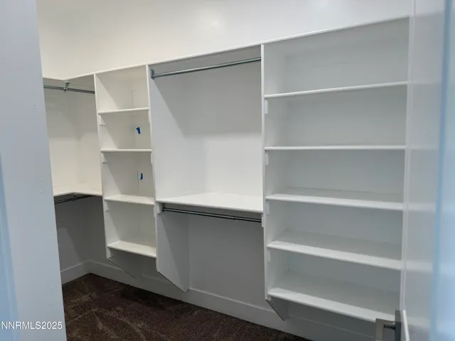 a view of walk in closet with empty racks