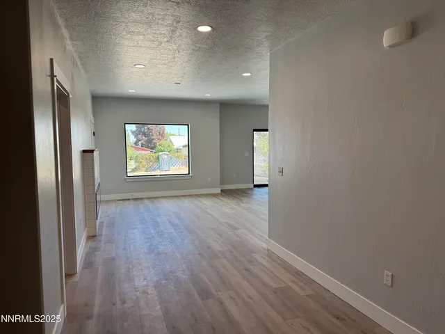 an empty room with wooden floor and a window