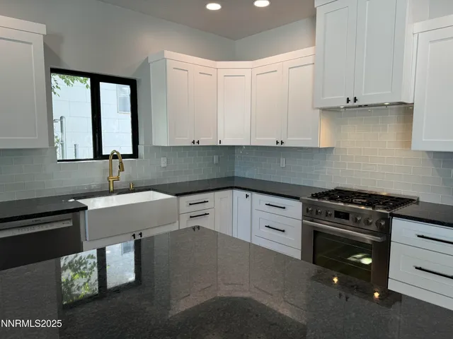 a kitchen with stainless steel appliances granite countertop a sink stove and cabinets