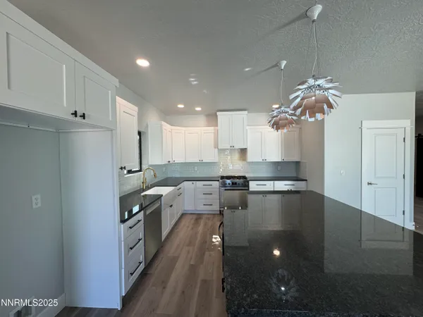 a large kitchen with kitchen island a stove a sink dishwasher and a refrigerator with wooden floor