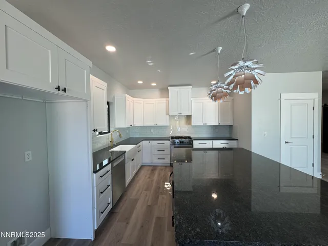 a large kitchen with kitchen island a stove a sink dishwasher and a refrigerator with wooden floor