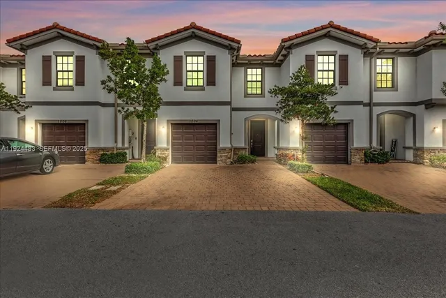 a front view of a house with yard and parking