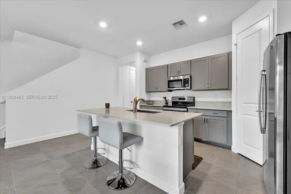 a kitchen with a refrigerator and a stove top oven