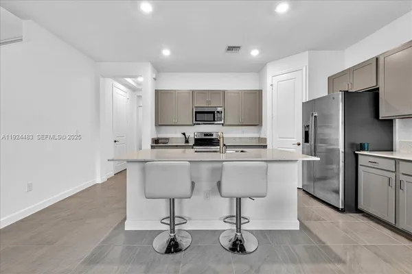 a kitchen with a sink cabinets and refrigerator