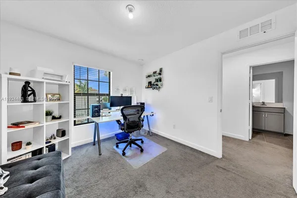 a livingroom with workspace and a couch