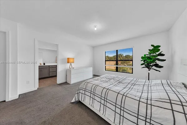 a bedroom with a large bed and a potted plant