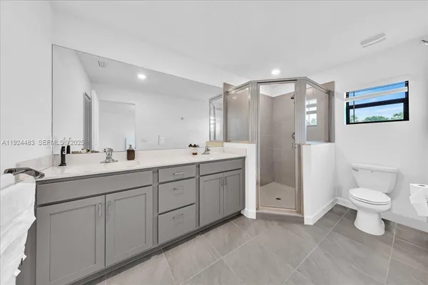 a spacious bathroom with a double vanity sink mirror and toilet
