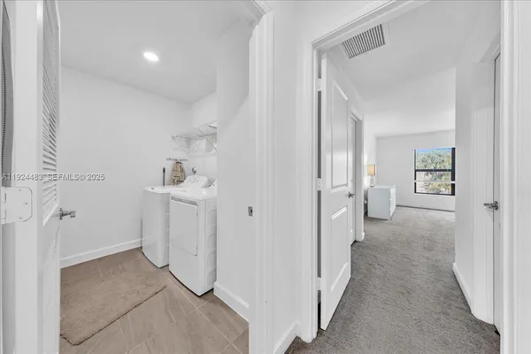 a view of a hallway with closet and utility room
