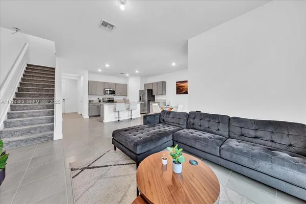 a living room with furniture and a wooden floor