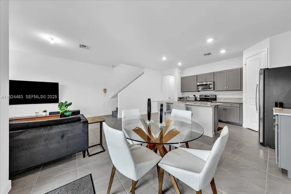 a view of a dining room with furniture and a kitchen