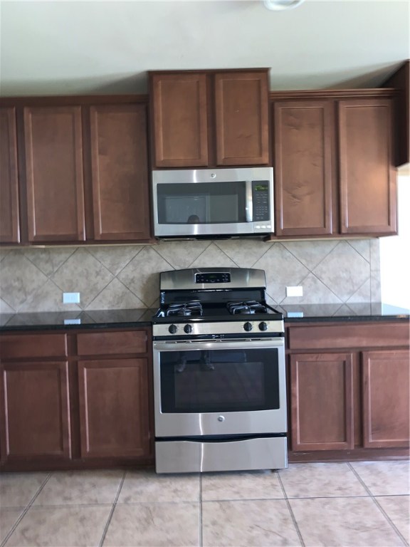 151 Chickadee Cove Kyle, TX 78640 - Photo 5 of 29 a kitchen with stainless steel appliances granite countertop wooden cabinets and a stove top oven