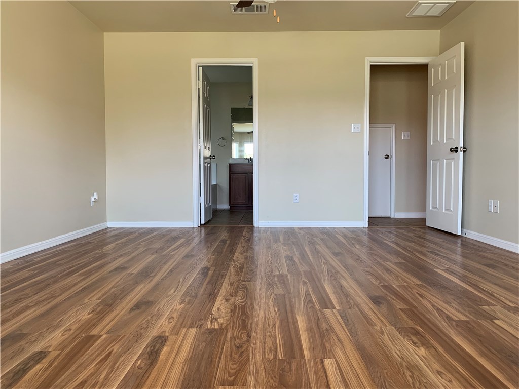 151 Chickadee Cove Kyle, TX 78640 - Photo 8 of 29 a view of a room with wooden floor and a bathroom