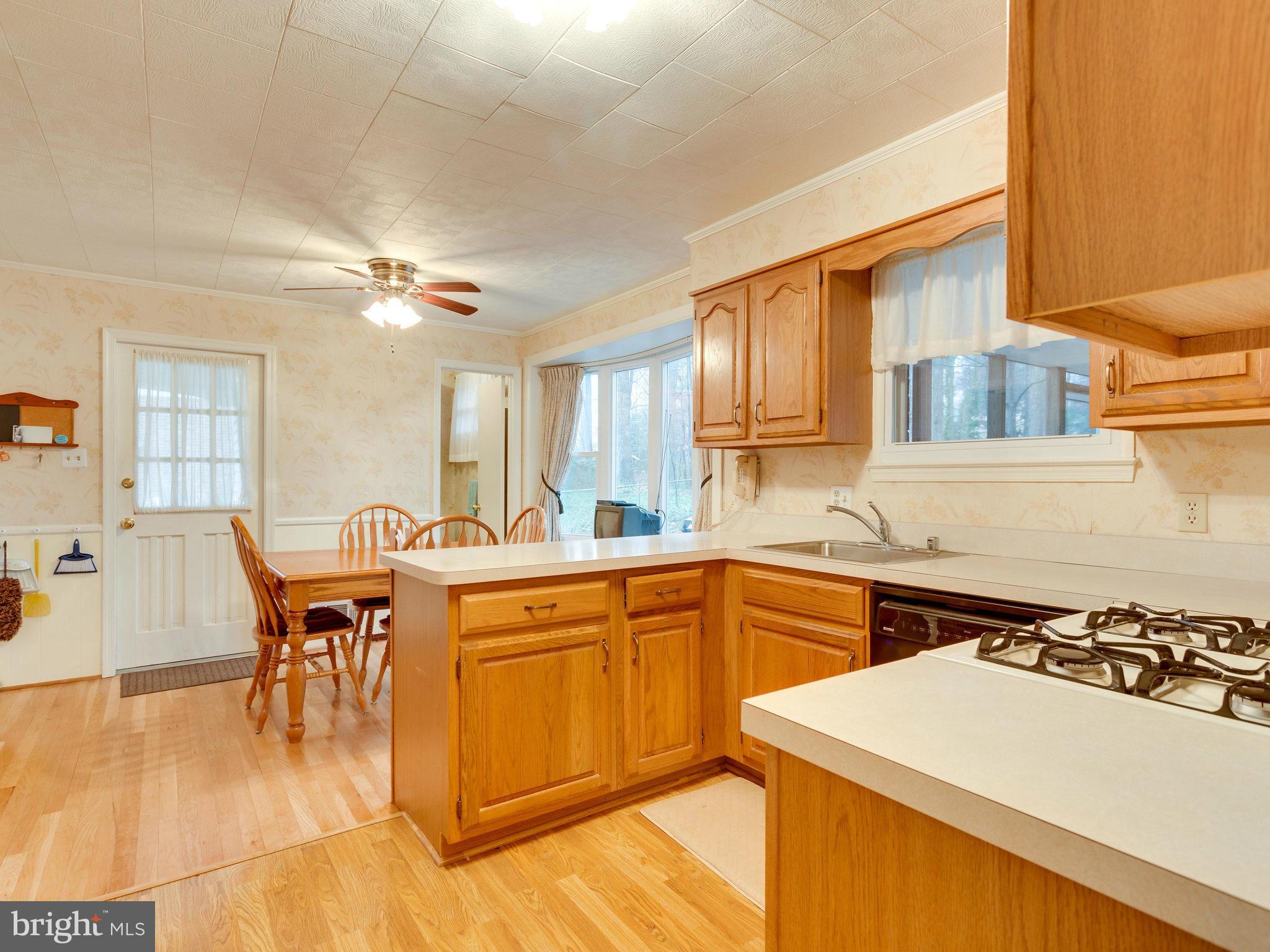 8613 Victoria Road Springfield, VA 22151 - Photo 2 of 21 a kitchen with a table chairs stove and wooden floor