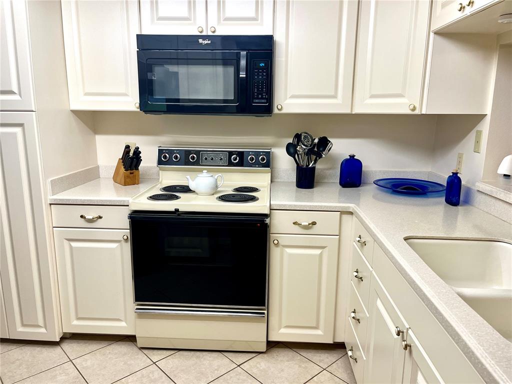 6503 Stone River Road, Unit 109 Bradenton, FL 34203 - Photo 11 of 65 a kitchen with stainless steel appliances granite countertop a stove and a microwave