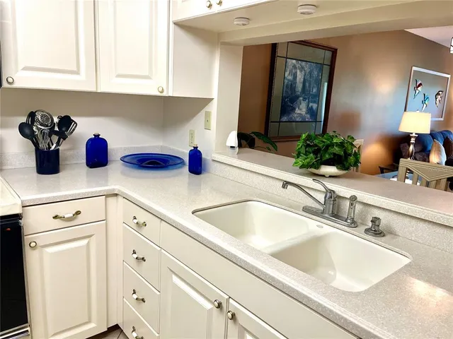 a kitchen with a sink dishwasher and cabinets with wooden floor