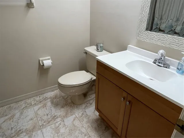 a bathroom with a sink toilet and a mirror