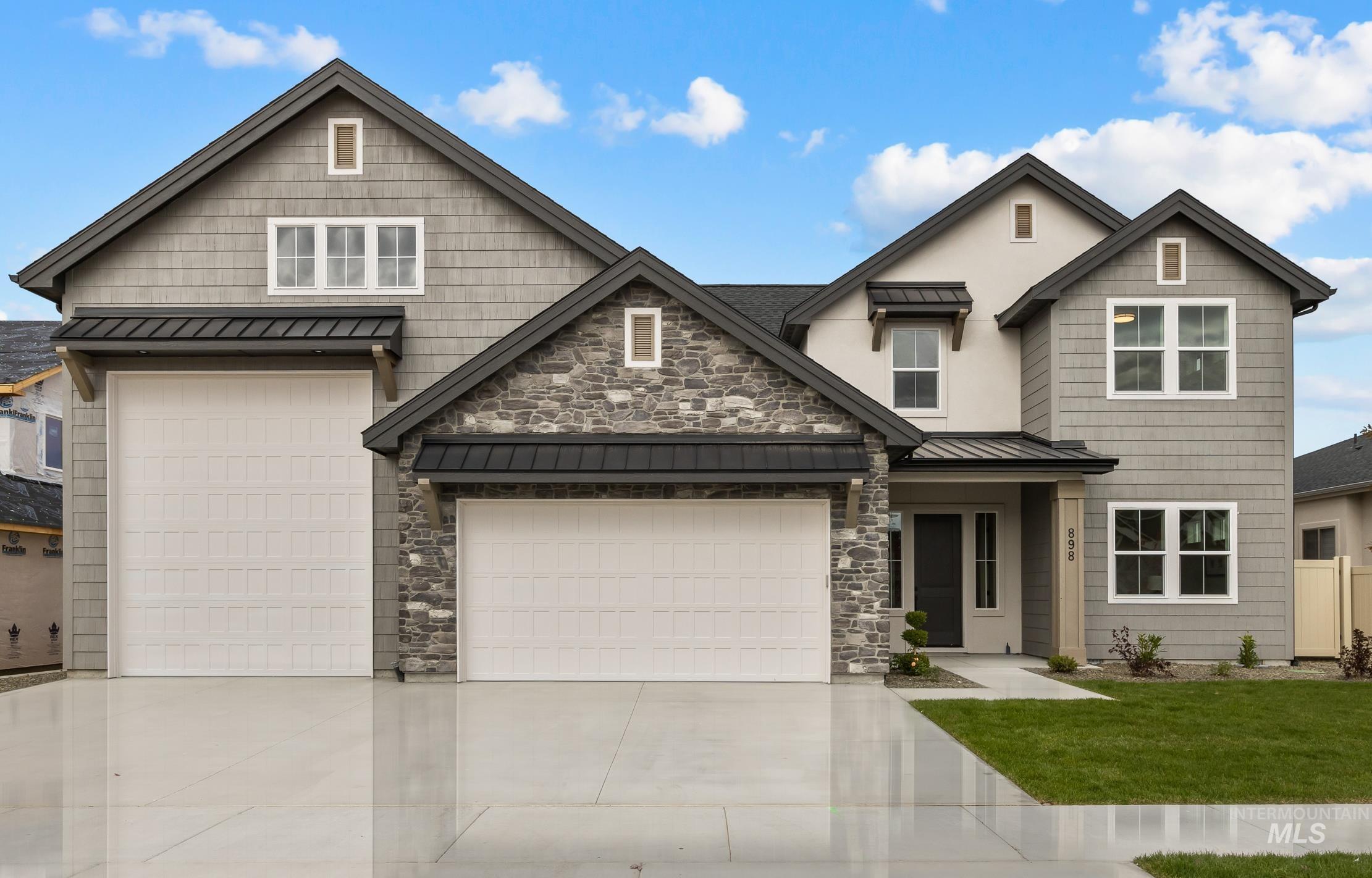 Craftsman house with a standing seam roof, a metal roof, stone siding, concrete driveway, and a front yard