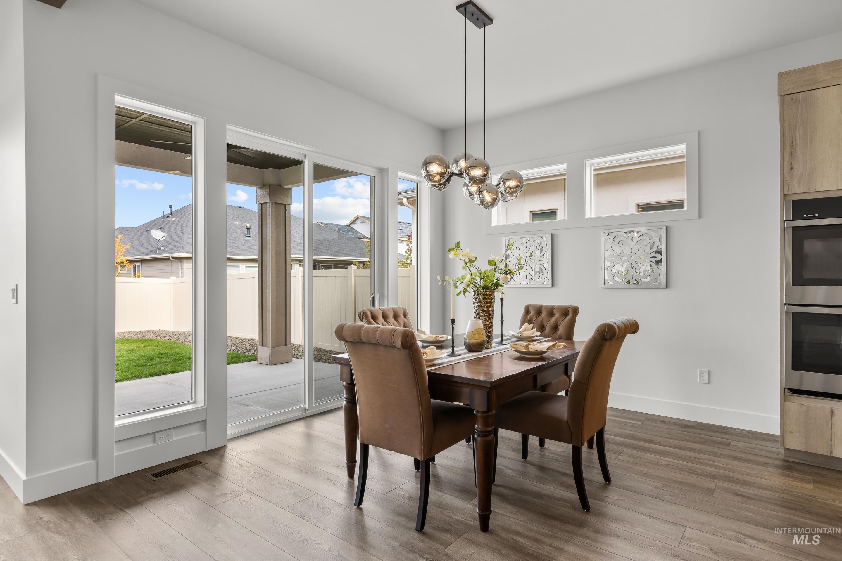 13 Blk 7 E Strut Way Boise, ID 83716 - Photo 11 of 50 Dining space featuring dark wood-style flooring and a chandelier