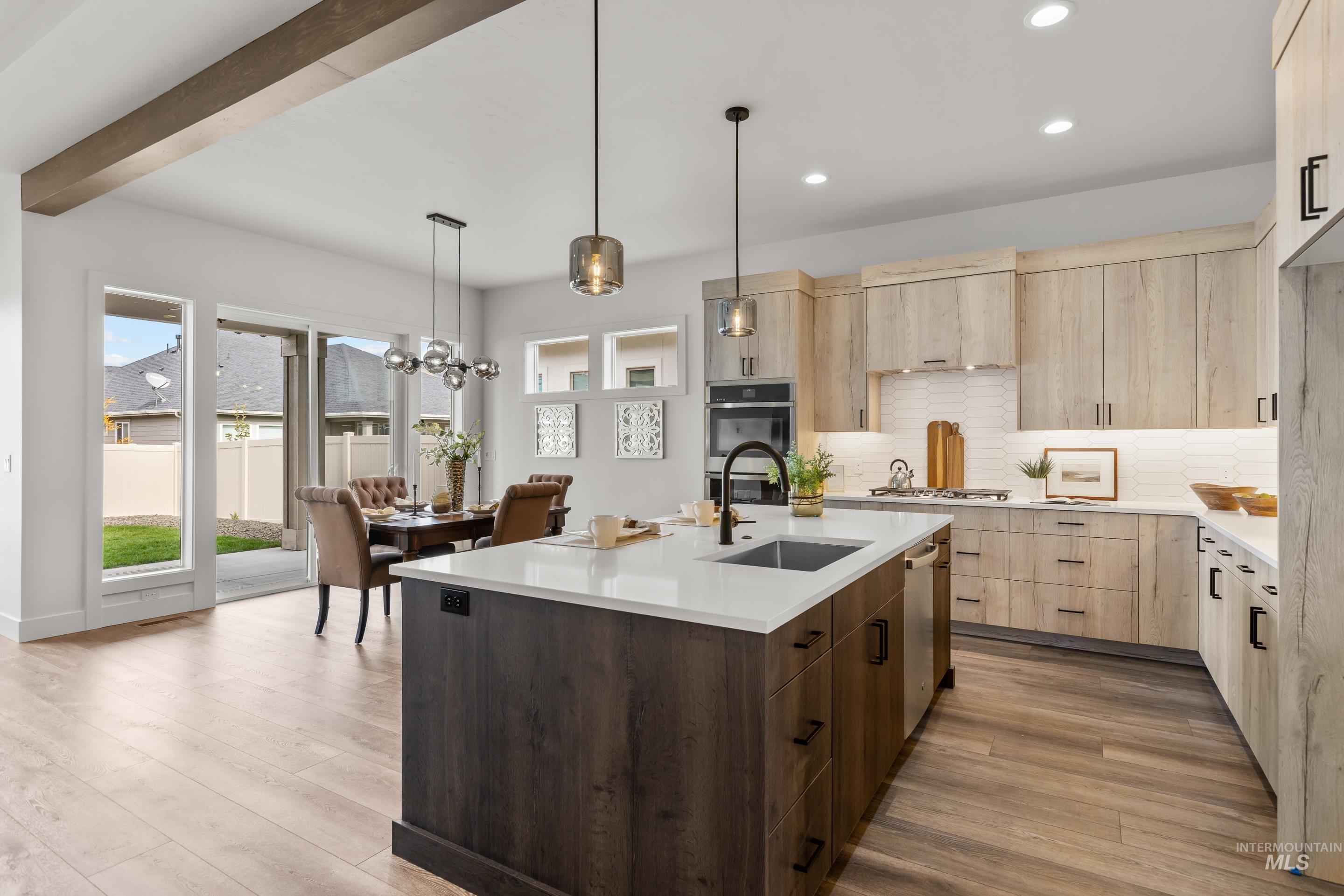 13 Blk 7 E Strut Way Boise, ID 83716 - Photo 15 of 50 Kitchen with light brown cabinets, light stone countertops, light wood-type flooring, decorative light fixtures, and a chandelier