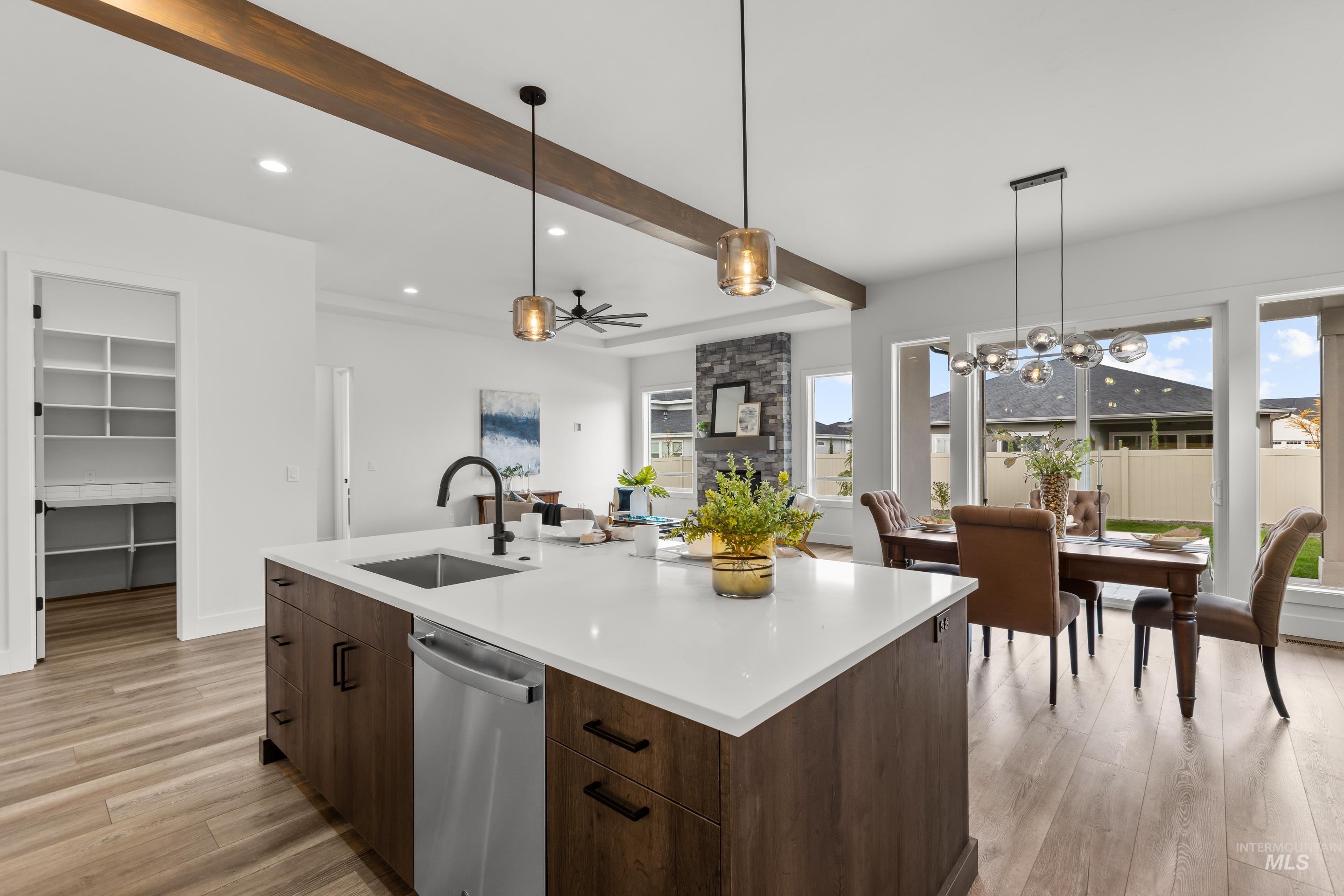 13 Blk 7 E Strut Way Boise, ID 83716 - Photo 20 of 50 Kitchen with light wood-style floors, beamed ceiling, stainless steel dishwasher, decorative light fixtures, and dark brown cabinets