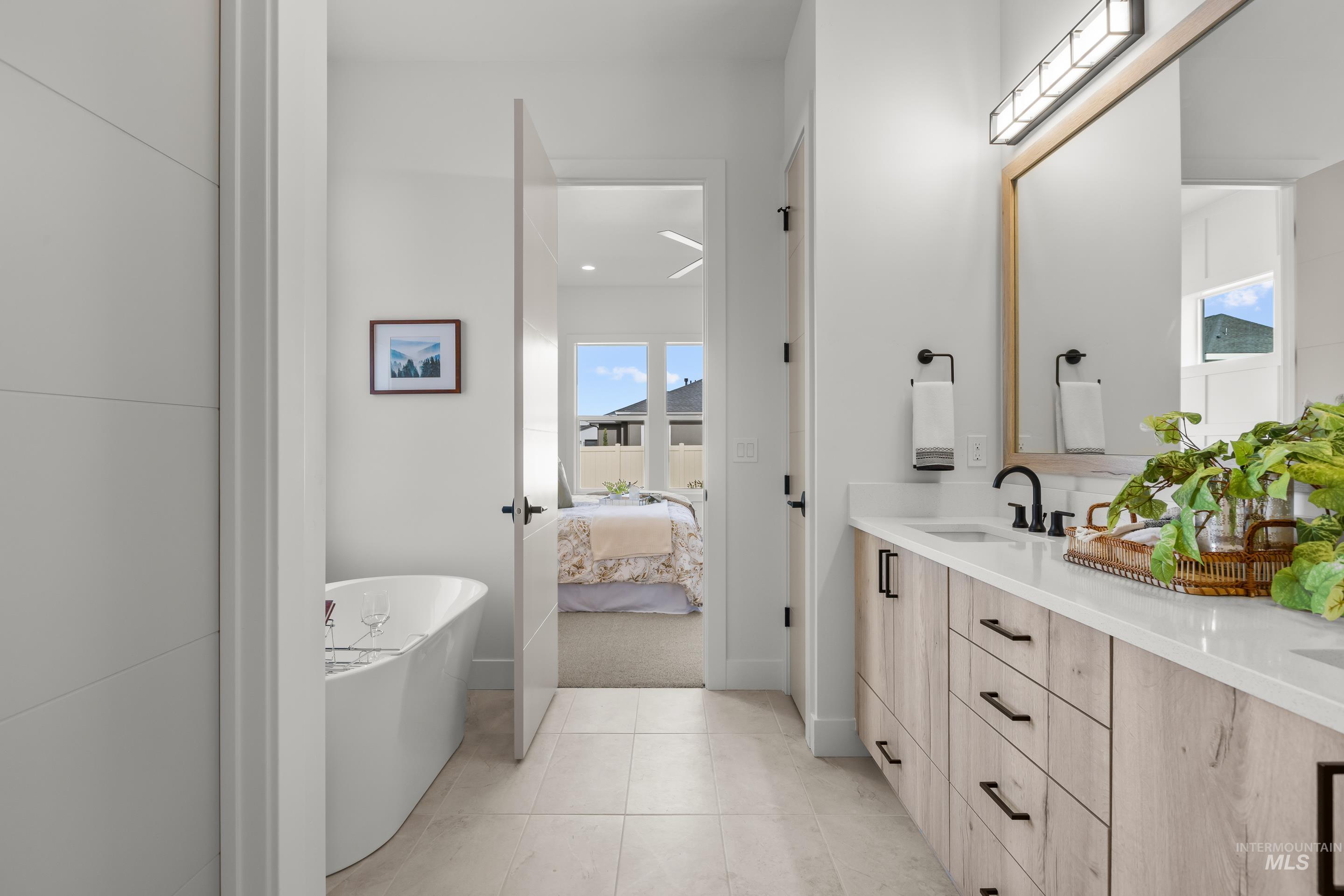 13 Blk 7 E Strut Way Boise, ID 83716 - Photo 30 of 50 Full bathroom featuring ensuite bathroom, double vanity, a freestanding tub, and light tile patterned floors