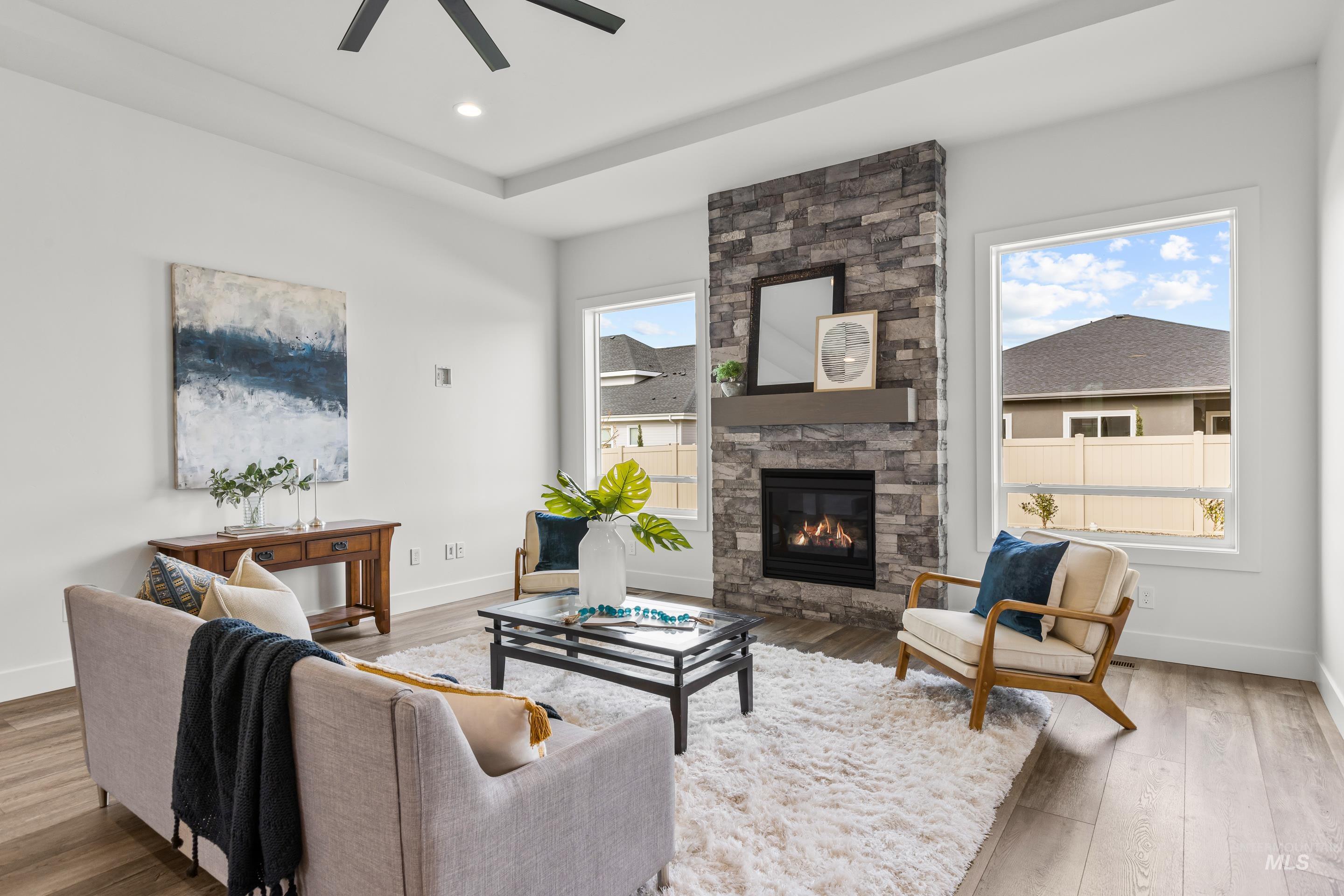 13 Blk 7 E Strut Way Boise, ID 83716 - Photo 5 of 50 Living area with a stone fireplace, wood finished floors, a raised ceiling, and recessed lighting