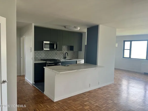 a large white kitchen with a stove top oven