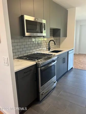 a kitchen with stainless steel appliances a stove sink and microwave