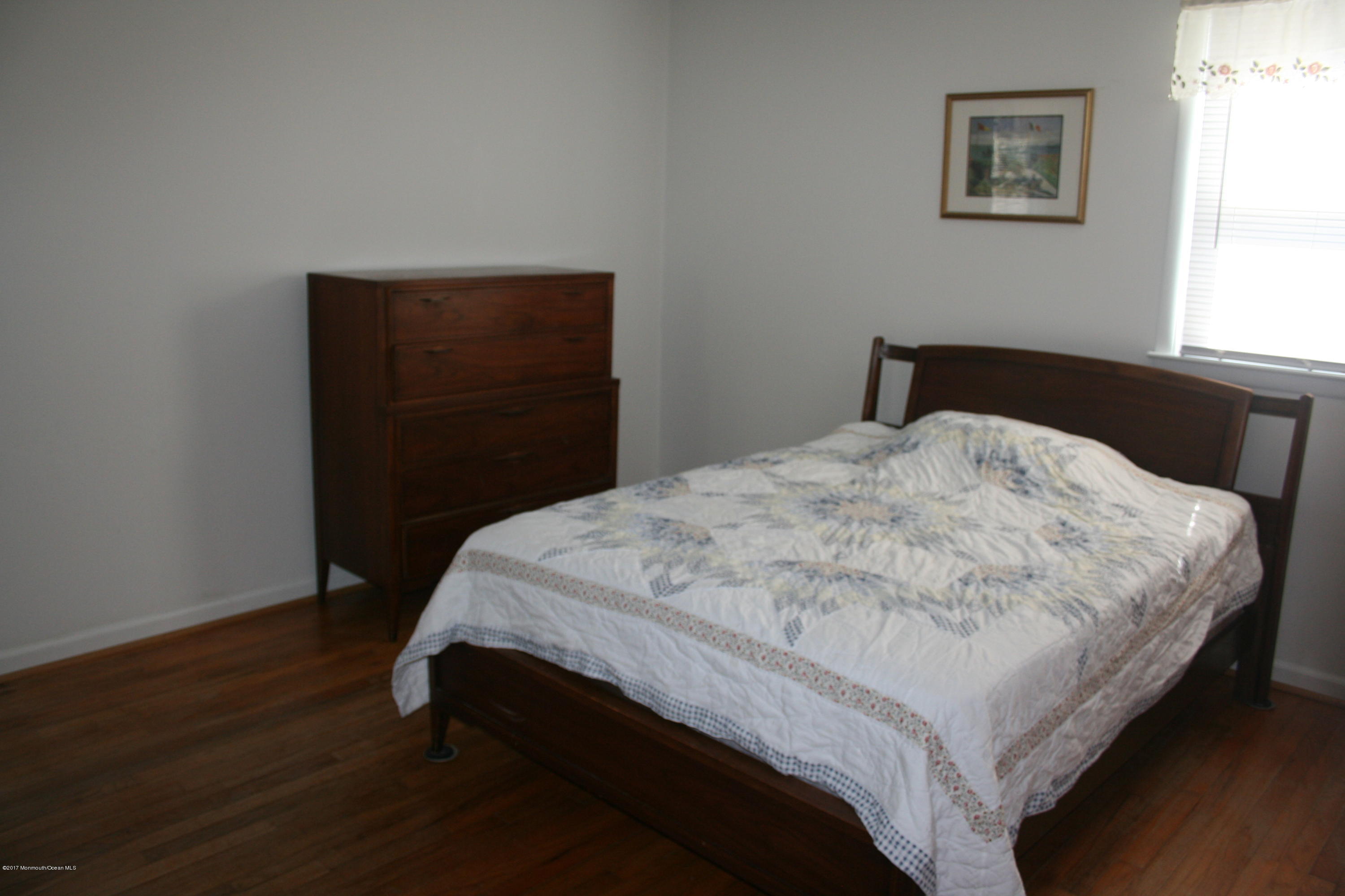 867 Monmouth Road Cream Ridge, NJ 08514 - Photo 14 of 19 a bedroom with a bed and wooden floor