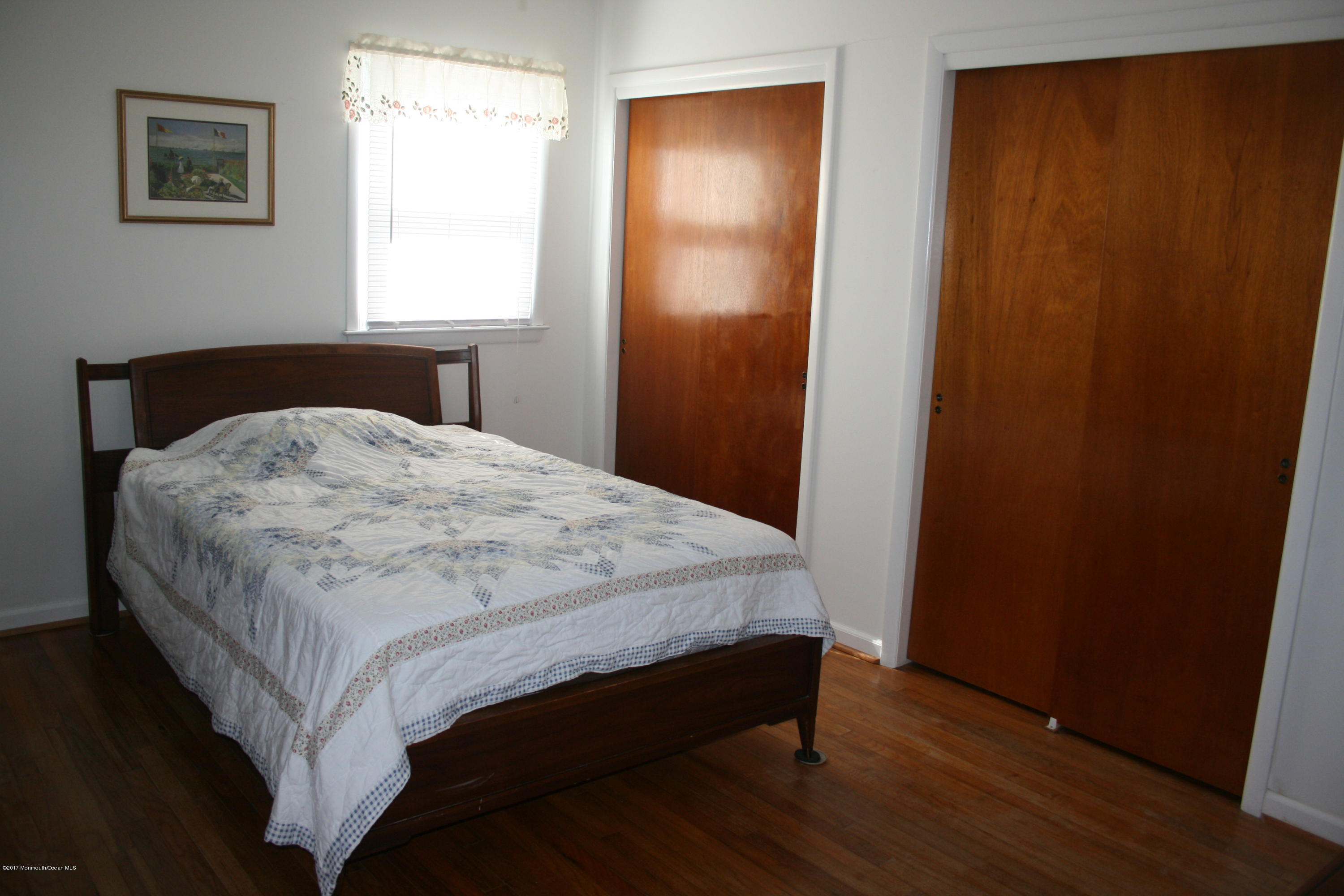 867 Monmouth Road Cream Ridge, NJ 08514 - Photo 15 of 19 a bed sitting in a bedroom next to a wooden cabinet