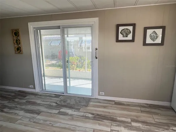 a view of a room that has a bed with wooden floor