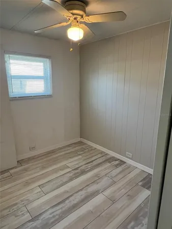 a view of empty room with wooden floor