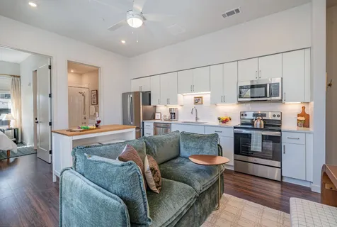 a living room with stainless steel appliances kitchen island granite countertop furniture and a kitchen view
